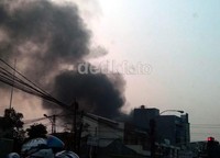 Asap terlihat tebal dan membumbung tinggi. Api terus membesar, karena toko material tersebut berisi kayu-kayu yang mudah terbakar.