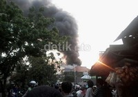 Para warga menggunakan ember ikut menjinakan si jago merah. Sebagian lagi hanya menonton.