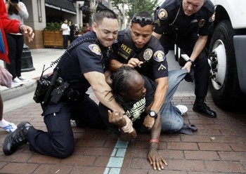     Polisi Pasadena, California menahan salah satu gelandangan yang membuat ricuh antrian iPhone. (kredit foto: MCT)