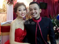 Keduanya tampak serasi mengenakan busana bernuansa merah dan hitam.