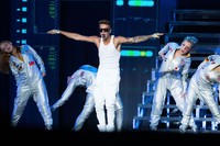 Bersama para penari latar, Justin Bieber menyuguhkan tarian yang energik di atas panggung. Nicky Loh/Getty Images.
