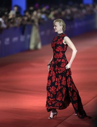 Nicole Kidman melangkah penuh percaya diri dalam balutan gaun hitam bermotif bunga merah dari Prada yang berhiaskan kalung berlian. REUTERS/Jason Lee.
