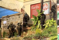 Pasukan Pertahanan Kenya bersenjata lengkap mengendap-endap menuju lokasi penyanderaan. Reuters/Noor Khamis