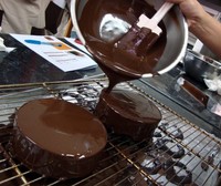 Teknik enrobing, yakni menyelimuti seluruh bagian kue dengan cokelat leleh.