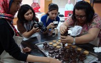 Peserta pelatihan tampak serius melakukan teknik enrobing untuk membuat Alfajores yang berbahan biskuit.