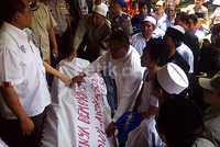 Para pendemo membawa keranda mayat ke kantor kelurahan.