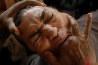 Seorang pria menelan ikan hidup-hidup karena dipercaya sebagai obat, di sebuah kamp di Hyderabad, India. (Foto: Reuters)