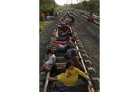 Warga berbaring di rel kereta api di Rawa Buaya di provinsi Jawa Barat, Indonesia. (Foto: Reuters)