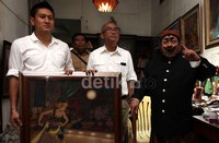 Drs Suyadi (Pak Raden) menyerahkan lukisan berjudul Perang Kembang kepada koordinator media center Prabowo Subianto Budi Purnomo Karjodihardjo di Petamburan, Jakarta Pusat, Selasa (1/10/2013).