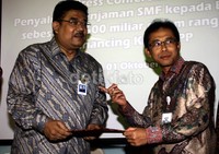 Dirut PT Sarana Multigriya Finansial (SMF) Raharjo Adisusanto (kanan) menyerahkan naskah perjajian dalam refinancing KPR-FLPP kepada Direktur Bank BTN Saut Pardede (kiri). Lamhot Aritonang/detikFoto.