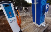 Pekerja merapihkan dan meratakan tanah yang nantinya akan dijadikan lahan parkir mobil listrik untuk mengisi bahan bakar.
