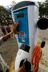 Pekerja menjajal stasiun pengisian mobil listrik.