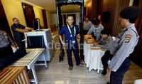 Seorang wartawan diperiksa dengan metal detektor.