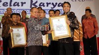 Direktur SDM & Umum PT Garuda Indonesia (Persero) Tbk. Heriyanto Agung Putra (kanan) menerima penghargaan dari Menteri Koperasi dan UKM, Syarif Hasan.