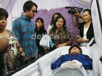 Mengenakan kemeja flanel berwarna biru, Ello tampak menyembunyikan raut kesedihan di wajahnya dengan kaca mata hitam.