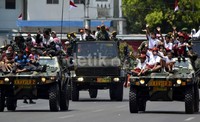 Siswa SD terlihat senang mengikuti defile dengan naik kendaraan TNI.