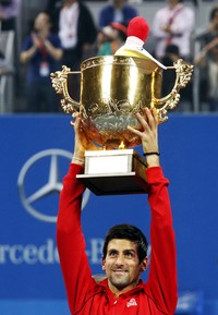 Novak Djokovic mengangkat trofi China Terbuka. Djokovic menjadi juara setelah mengalahkan Rafael Nadal, Minggu (6/10/2013) sore WIB. Reuters/Jason Lee.