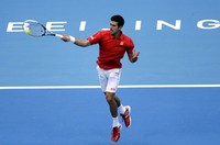 Novak Djokovic melakukan smash saat melawan Rafael Nadal di final China Terbuka. Reuters/Jason Lee.