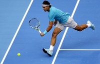 Rafael Nadal berusaha mengembalikan bola saat melawan Novak Djokovic di final China Terbuka. Reuters/Jason Lee.