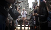 Di acara tersebut, Miley tampil mengenakan atasan dari Kenzo dipadu dengan celana pendek dan sepatu tuck berwarna ungu. REUTERS/Carlo Allegri.