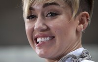 Ini dia mimik muka yang lucu dari Miley Cyrus. REUTERS/Carlo Allegri.