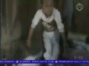 Seorang Guru Menggendong Anak Saat Mengajar