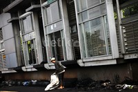 Seorang pemulung mengambil sisa-sisa kebakaran di depan halte.