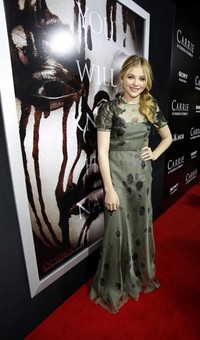 Bintang 'Kick-Ass 2' itu tampil mengenakan floral dress dari Valentino dengan detail renda hitam dan motif dandelion serta dilengkapi dengan perhiasan dari Draper Daniella. REUTERS/Mario Anzuoni.