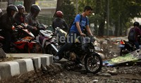 Para pemotor nekat menerobos jalan yang tengah diperbaiki.