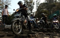 Agar dapat dilintasi, badan jalan yang telah dikupas tersebut ditutupi dengan puing-puing.