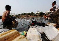 Sejumlah anak bermain di antara sampah di Banjir Kanal Barat.