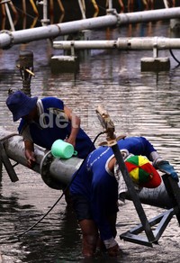 Pekerja memeriksa mesin pompa air di kolam bundaran HI.