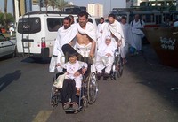 Beberapa jamaah haji berjalan kaki memasuki areal terowongan King Fahd. Jamaah membawa tas berisi perlengkapan selama di Arafah.