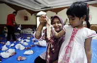 Panitia melakukan pemotongan dan pemisahan daging kurban untuk dimasukkan ke kantong plastik.