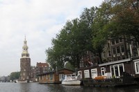 Aneka rumah dan bangunan di tepi kanal Amsterdam, di belakangnya ada menara gereja tua. Bangunan lain yang dilintasi rute canal cruise adalah gereja tertua di Belanda, yakni Oude Kerk (Uyung/detikTravel)