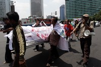 Massa mengarak keranda mayat.