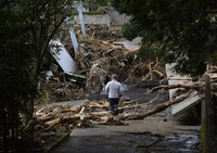 Topan ini menimbulkan sejumlah tanah longsor yang menimbun rumah-rumah di pulau Oshima hari ini. Pulau tersebut terletak sekitar 120 kilometer sebelah selatan Tokyo. REUTERS/Kyodo.