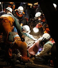 Petugas mengevakuasi para korban yang tertimbun longsoran. REUTERS/Kyodo.