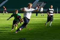 Tak mau kalah dengan anak-anak, Pangeran Harry berlari menjaga bola. Ian Gavan/Getty Images.