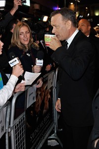 Tom Hanks terlihat sedang meminum segelas teh hangat ketika sesi wawancara. Gareth Cattermole/Getty Images.
