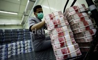Seorang petugas tampak merapihkan tumpukan uang di cash center Bank Negara Indonesia Pusat, kawasan Sudirman, Jakarta, Senin (21/10/2013).