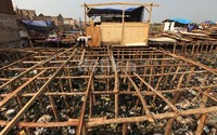 Mereka menancapkan tiang-tiang di atas puing-puing sisa kebakaran.