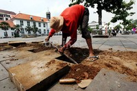 Seorang pekerja melakukan penggalian untuk pemasangan lampu penerangan.