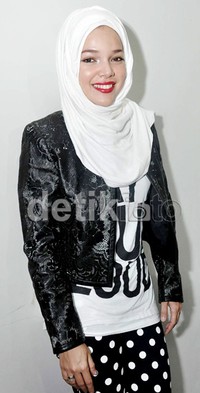 Dewi Sandra bergaya dengan hijab putih yang dipadukan dengan kaus putih bertuliskan 'Say It Out Loud', jaket kulit lace hitam dan celana polkadot hitam-putih. Noel/detikHOT.