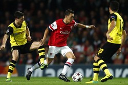 Mesut Ozil meliuk-liuk untuk melewati Henrikh Mkhitaryan dan Nuri Sahin. Reuters/Eddie Keogh.