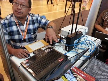 Onno W. Purbo, sang pakar TI dan open-source, menunjukkan demonstrasi perangkat Open BTS garapannya di salah satu booth pada event IGF 2013.     