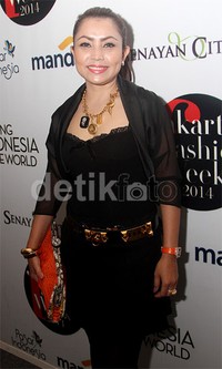 Clutch bag bermotif kulit ular dan jam tangan oranye menyentuh penampilan serba hitam Mayangsari. Gus Mun/detikHOT.