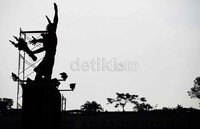 Para pekerja menyelesaikan pembersihan patung selamat datang yang menghadap ke arah Istana Presiden.