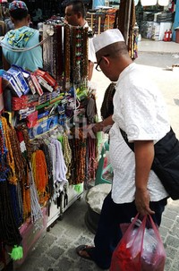 Para jamaah haji berburu cinderamata mulai dari tasbih, peci haji, minyak wangi, sajadah, hingga pakaian muslim.