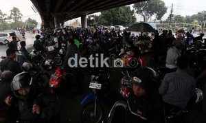 Pemotor yang Berteduh di Kolong Jembatan Saat Hujan Bikin Macet Jalan